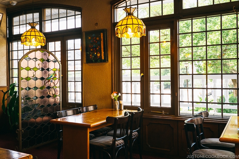 tables and chairs next to glass window and wall with square pattern