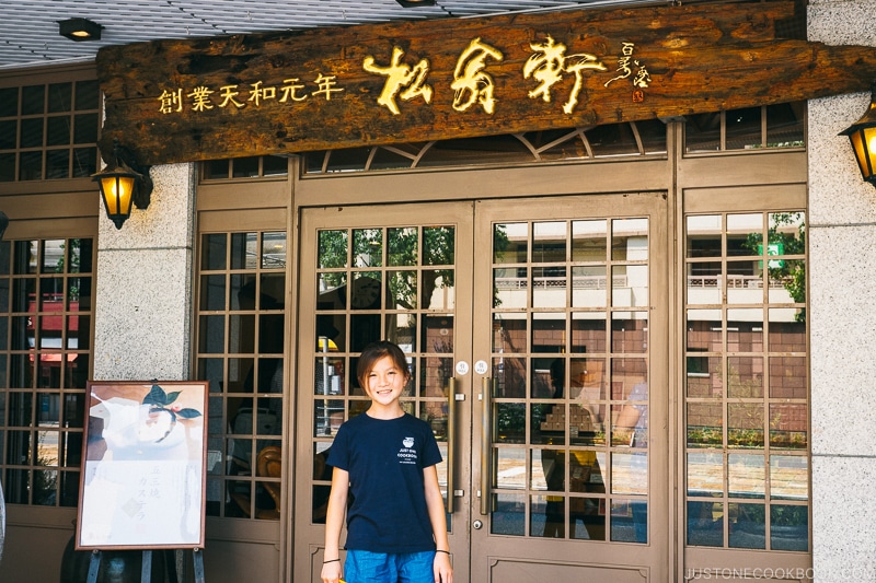 girl standing in front of a Japanese sweets store