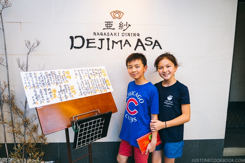 two children standing in front of Dejima Asa sign