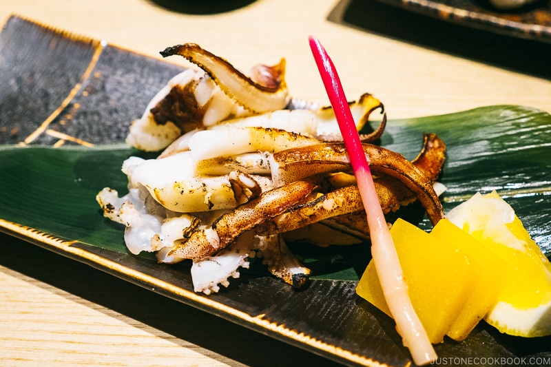 grilled squid legs on bamboo leaf