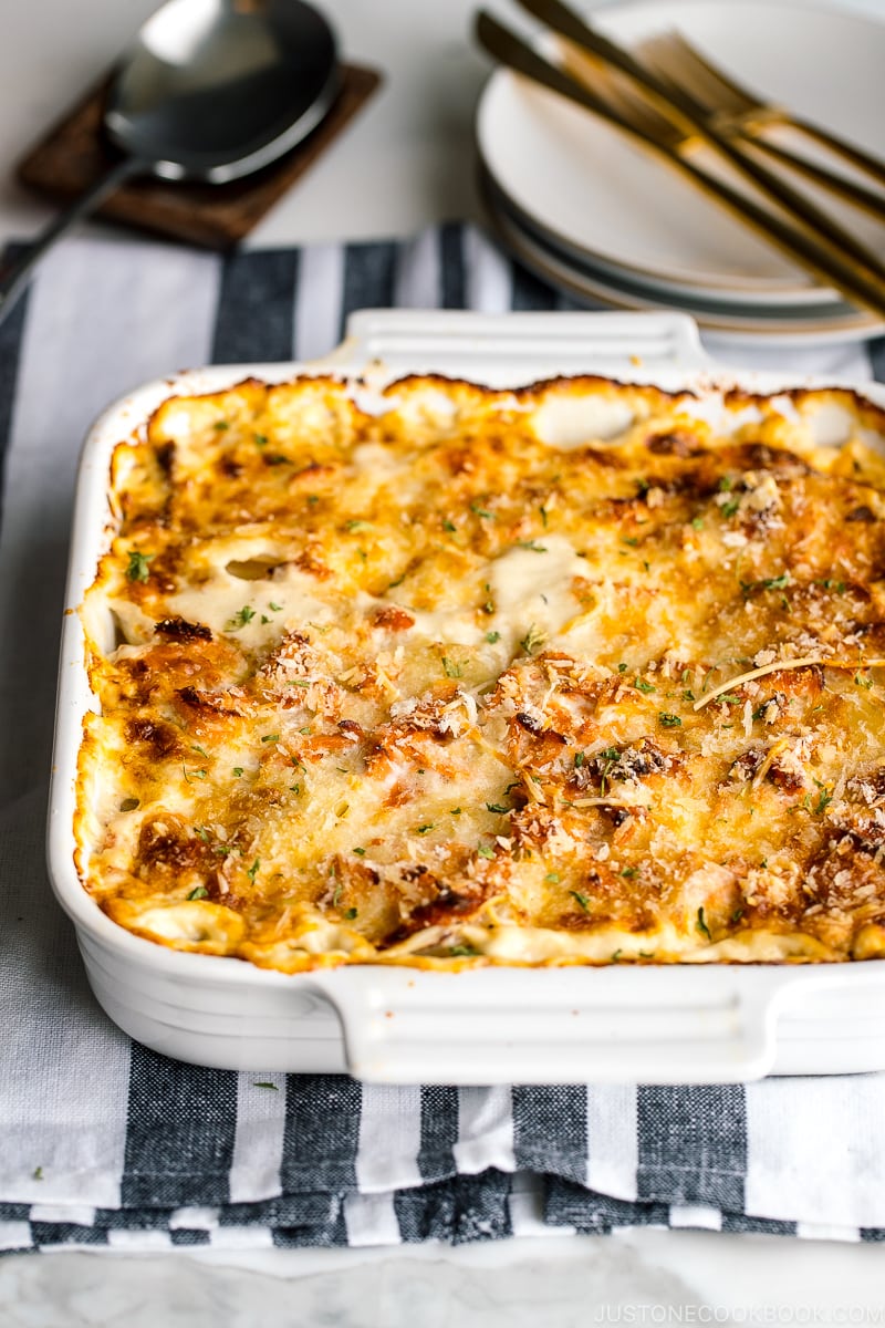 A white baking dish containing nicely charred Salmon Potato Gratin.