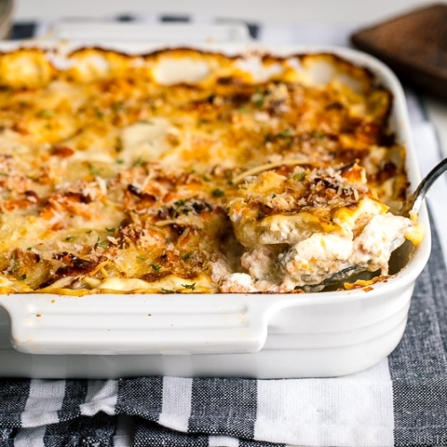 A white baking dish containing nicely charred Salmon Potato Gratin.