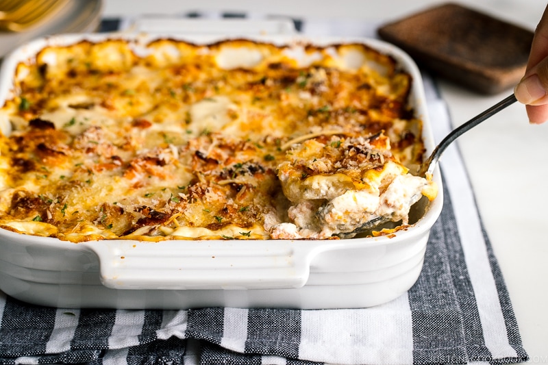 A white baking dish containing nicely charred Salmon Potato Gratin.