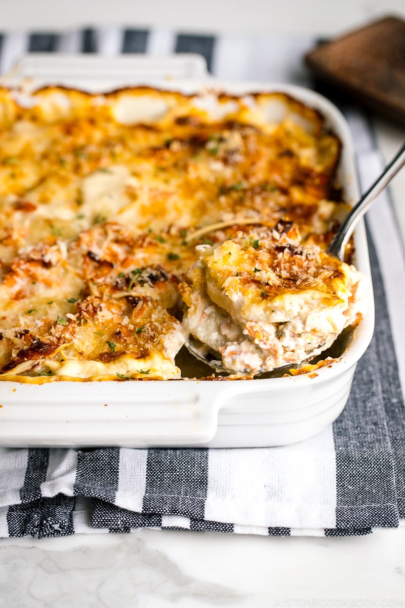 A white baking dish containing nicely charred Salmon Potato Gratin.