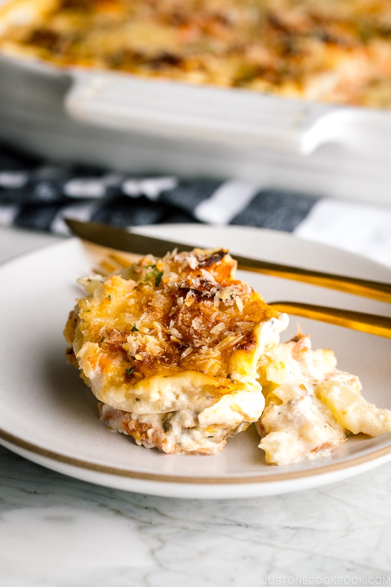 A white baking dish containing nicely charred Salmon Potato Gratin.