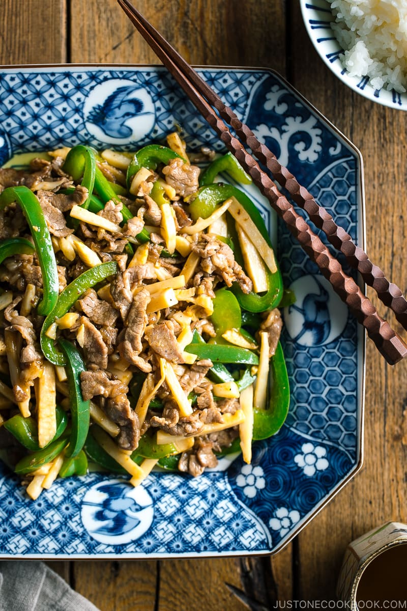 A Japanese blue and white ceramic containing Beef and Green Pepper Stir Fry.