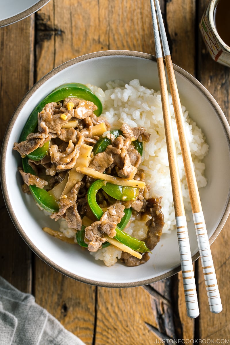 A white bowl containing steamed rice and Beef and Green Pepper Stir Fry.