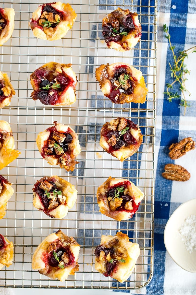 Cranberry Brie Bites placed on a wire rack garnished with thyme.