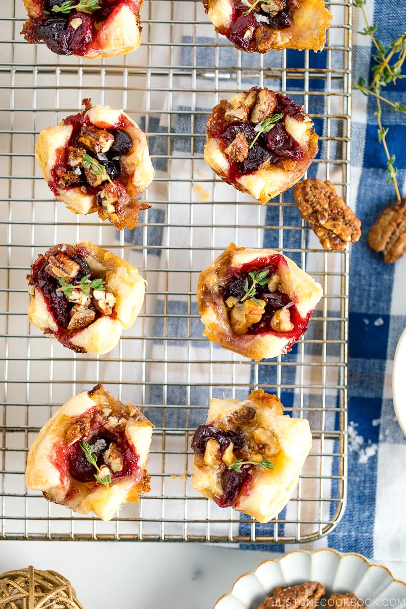 Cranberry Brie Bites placed on a wire rack garnished with thyme.