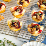 Cranberry Brie Bites placed on a wire rack garnished with thyme.