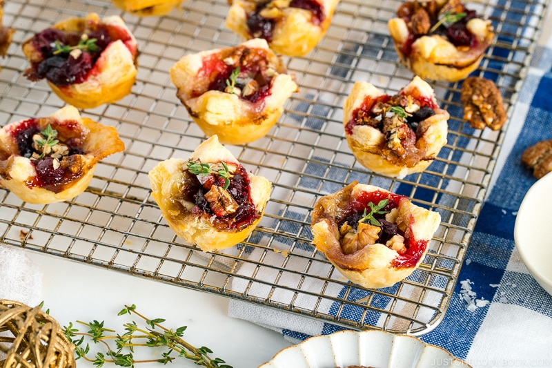 Cranberry Brie Bites placed on a wire rack garnished with thyme.