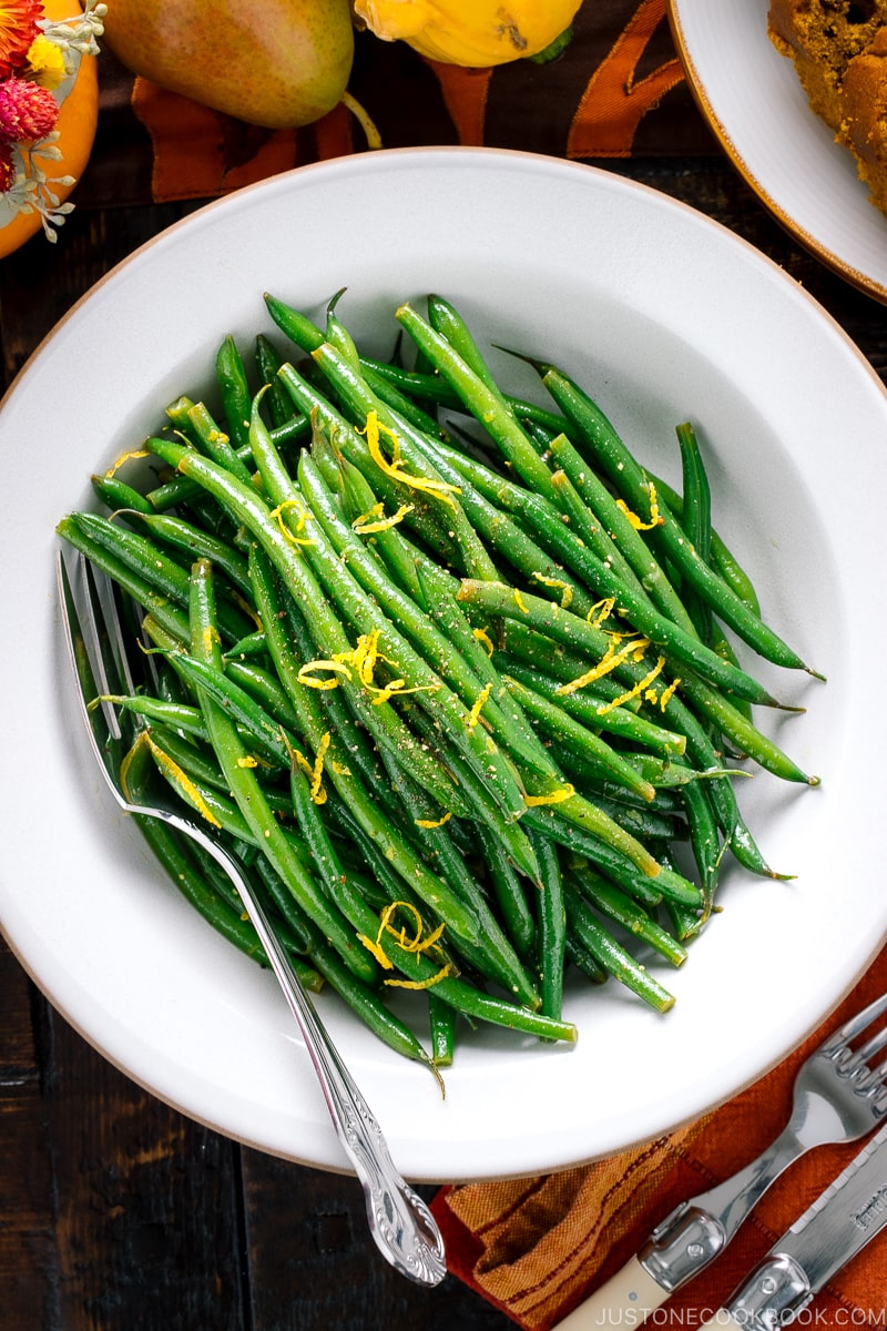 A white bowl containing Green Beans with Yuzu Vinaigrette.