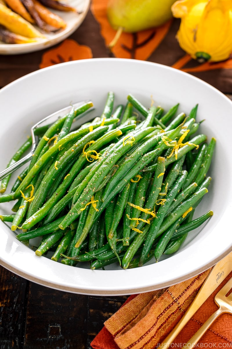 A white bowl containing Green Beans with Yuzu Vinaigrette.