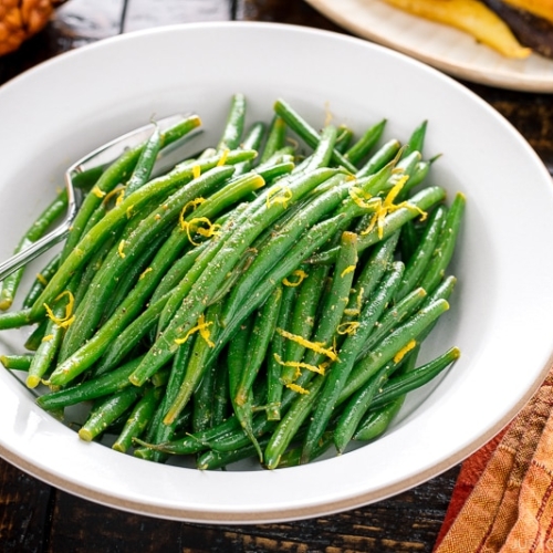 A white bowl containing Green Beans with Yuzu Vinaigrette.