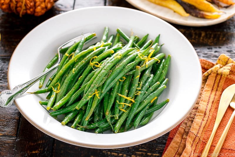 A white bowl containing Green Beans with Yuzu Vinaigrette.