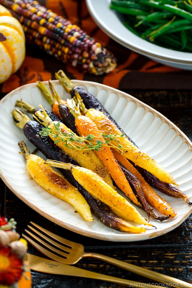 A white ceramic plate containing Maple and Miso Glazed Roasted Carrots.