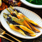 A white ceramic plate containing Maple and Miso Glazed Roasted Carrots.