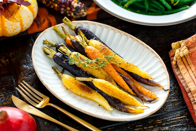 A white ceramic plate containing Maple and Miso Glazed Roasted Carrots.