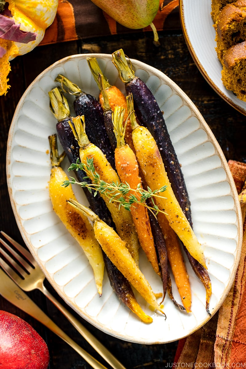 A white ceramic plate containing Maple and Miso Glazed Roasted Carrots.