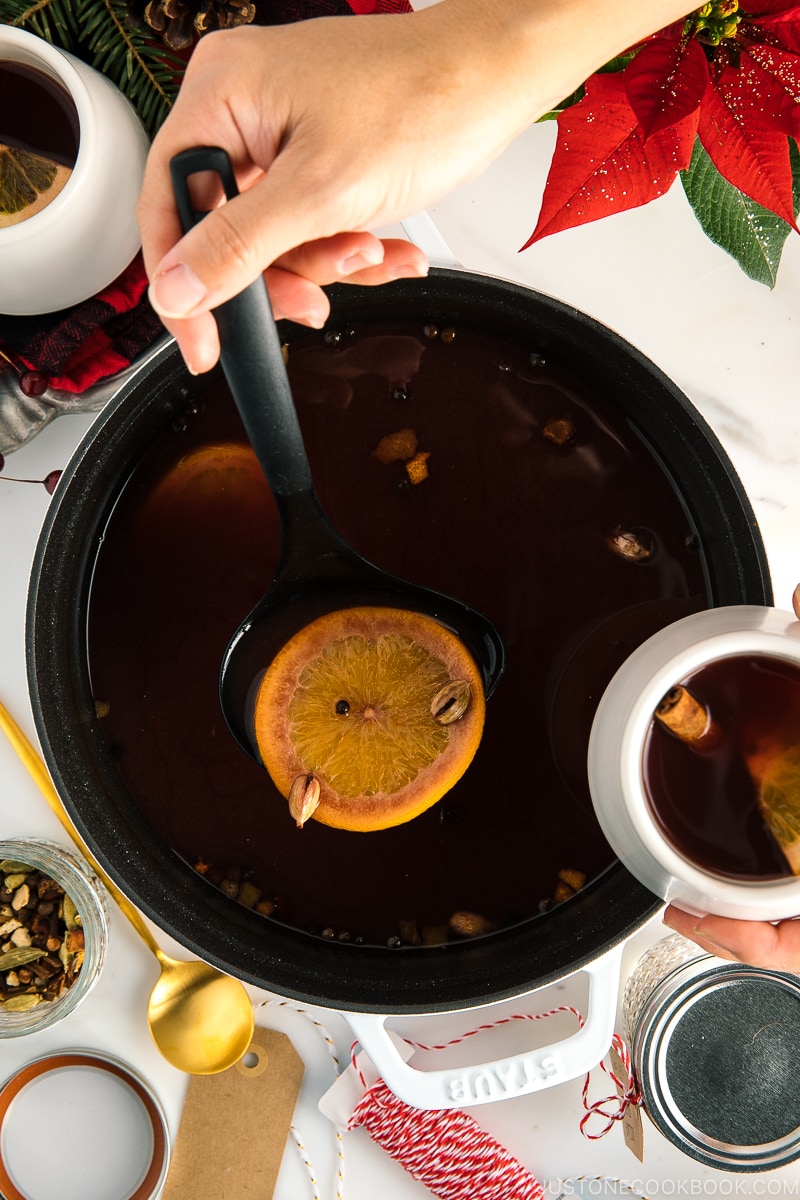 A white Staub cocotte containing hot mulled cider.