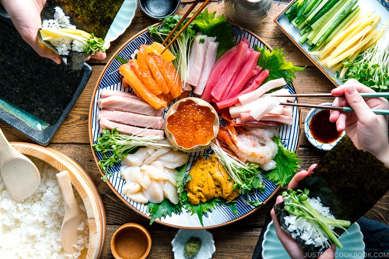 A sashimi platter with varioius sashimi (tuna, salmon, amaebi, uni, scallop, kanpachi, ikura and more), sushi rice, and vegetable platter.