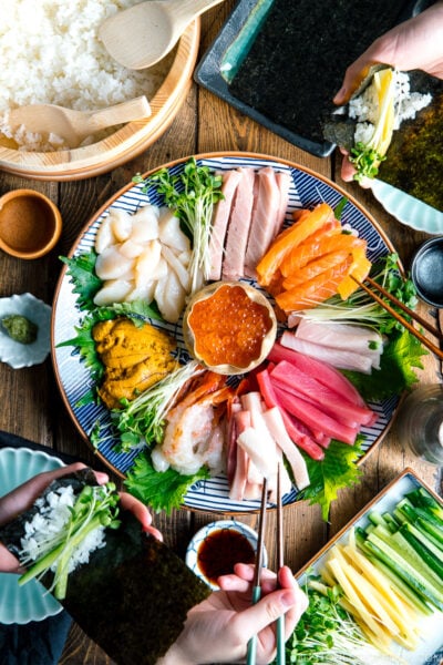 A sashimi platter with varioius sashimi (tuna, salmon, amaebi, uni, scallop, kanpachi, ikura and more), sushi rice, and vegetable platter.