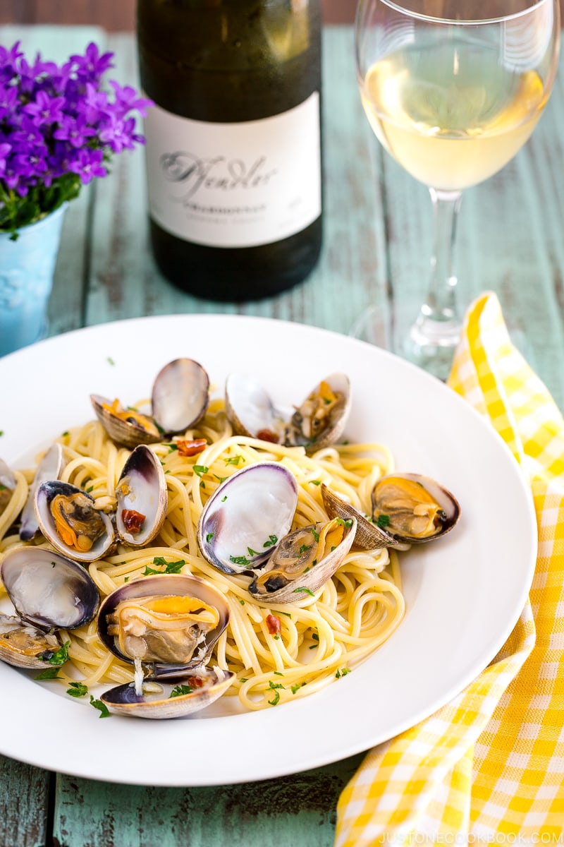 A white plate containing clam pasta.