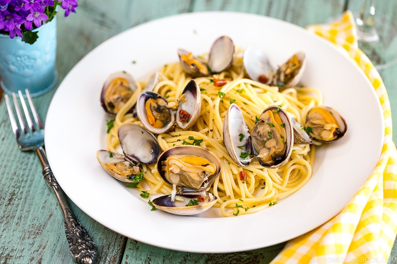 A white plate containing clam pasta.