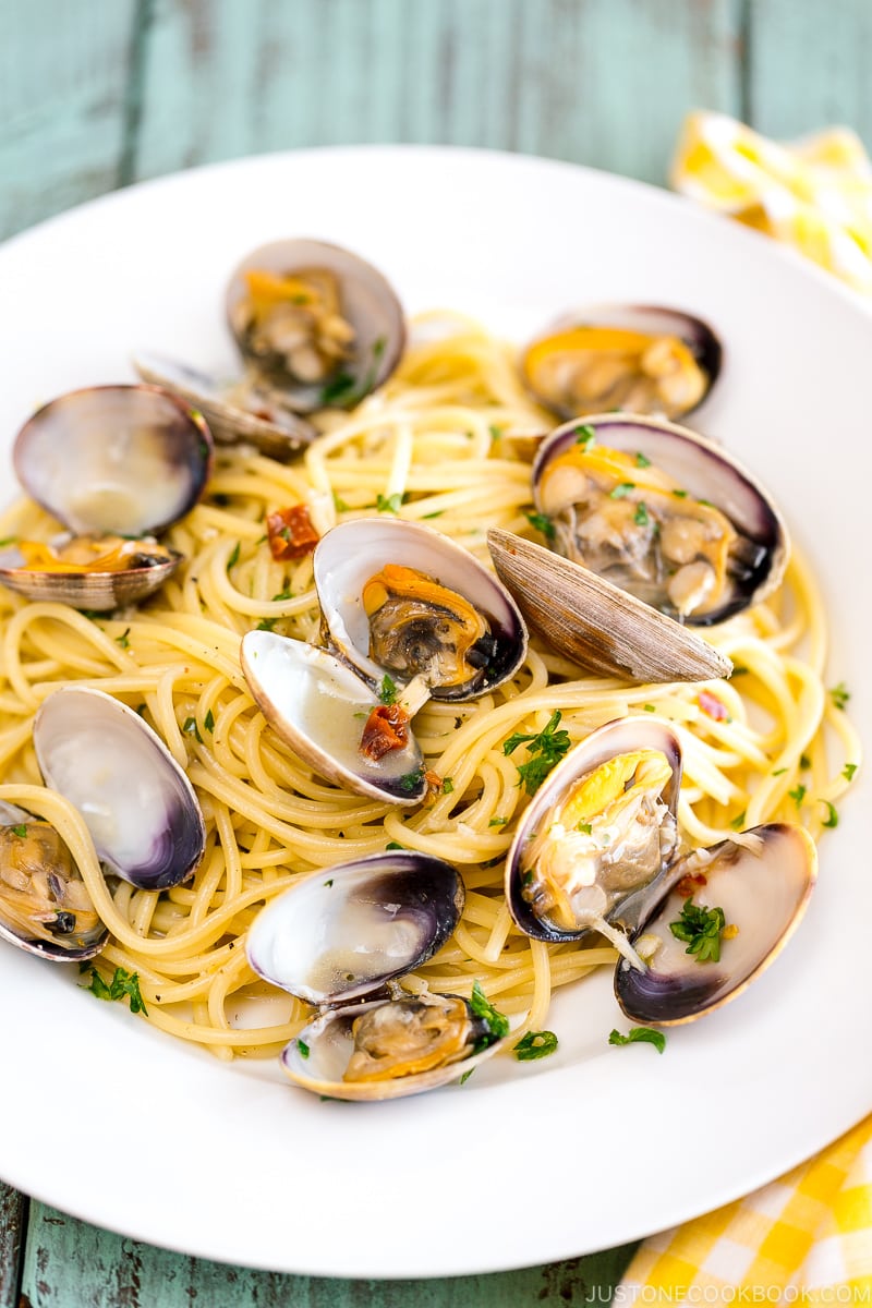 A white plate containing clam pasta.