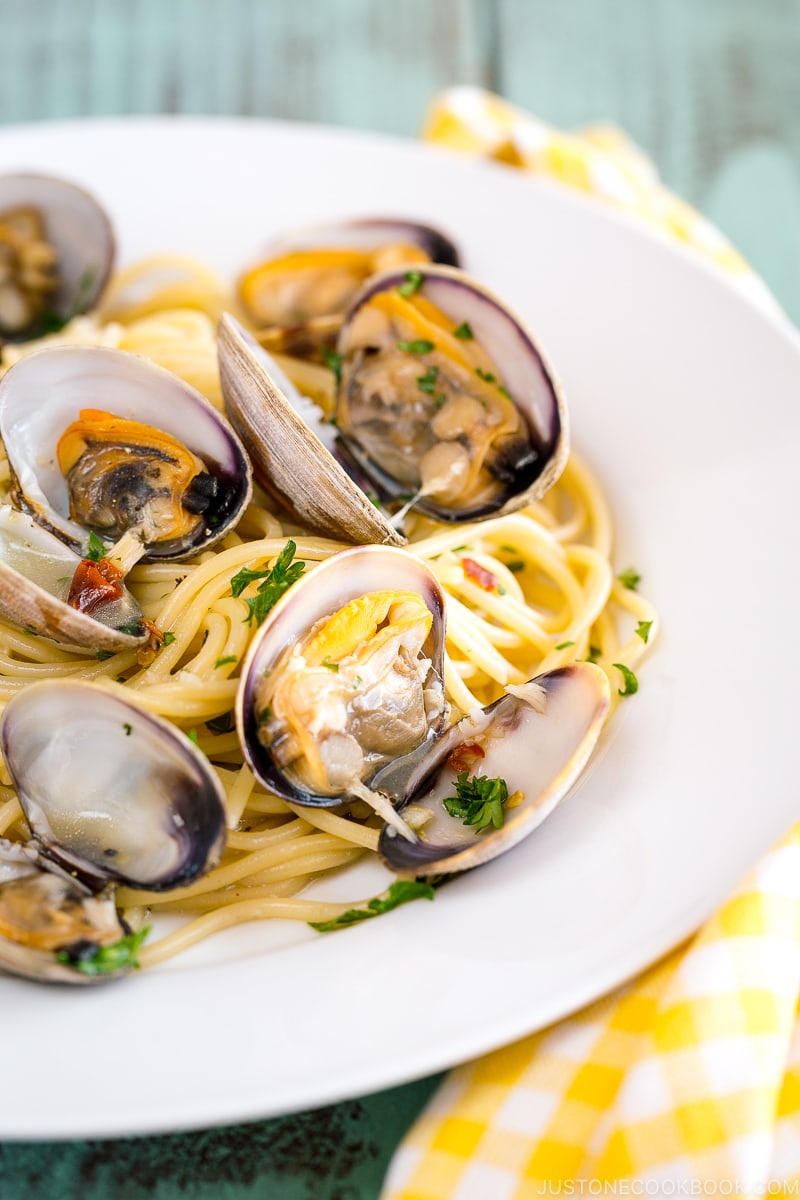 A white plate containing clam pasta.