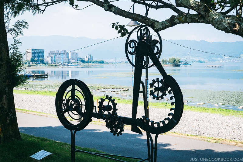 metal sculpture next to Lake Suwa