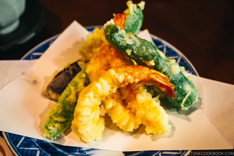 tempura shrimp and vegetables on top of a blue plate