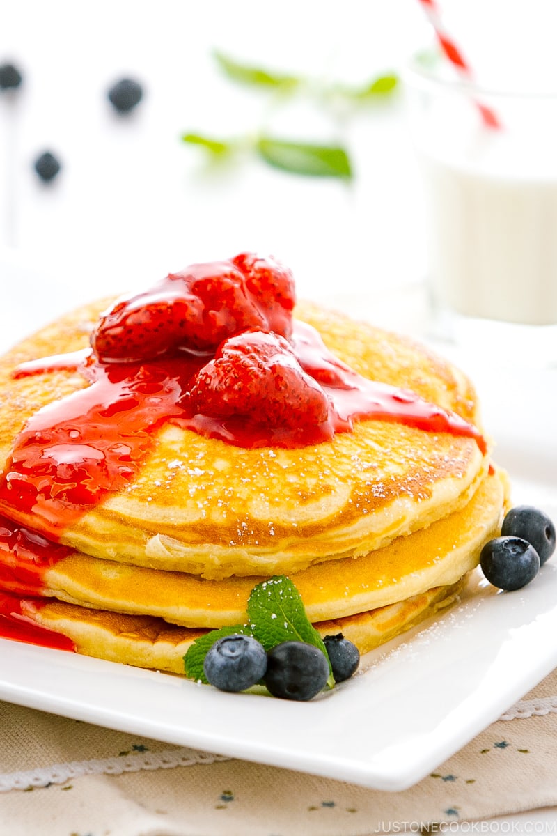 A dish containing Buttermilk Pancakes with strawberry compote.