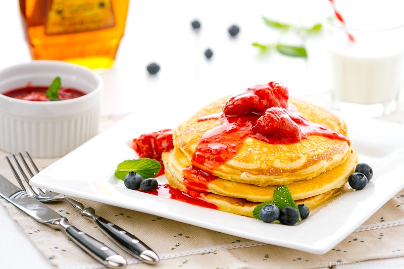 A dish containing Buttermilk Pancakes with strawberry compote.