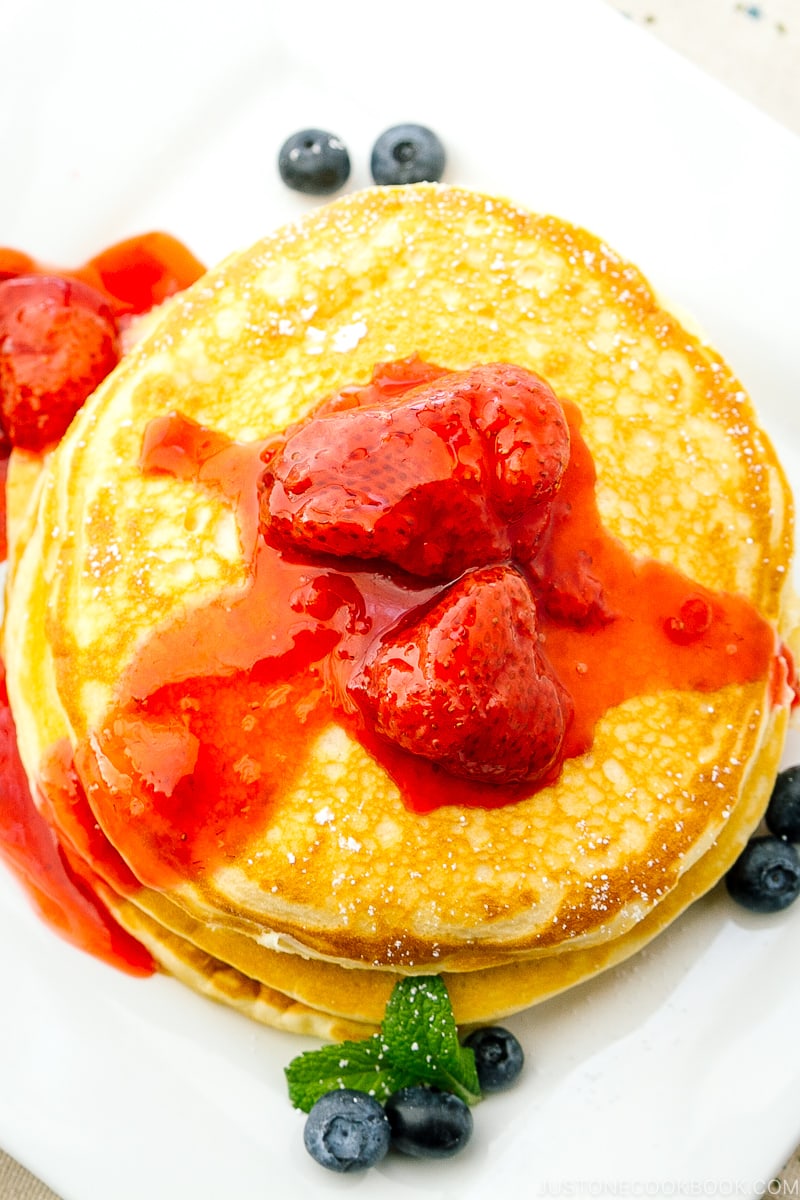 A dish containing Buttermilk Pancakes with strawberry compote.