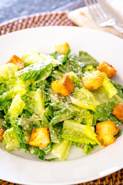 A white plate containing Caesar Salad with Homemade Croutons.
