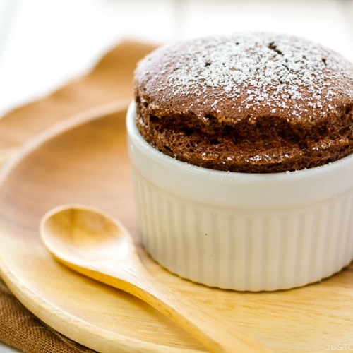 A white ramekin containing chocolate souffle.