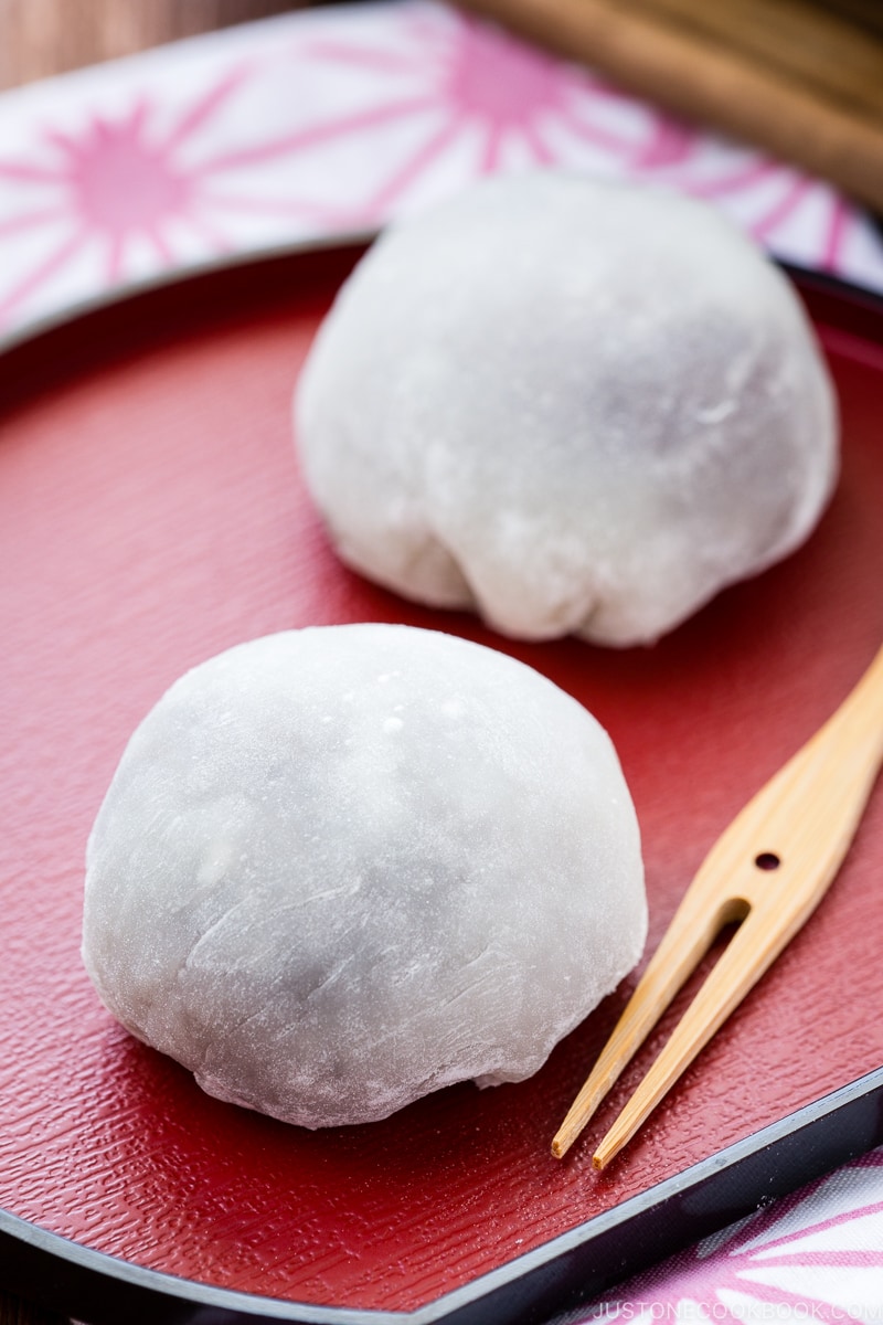 A Japanese red plate containing daifuku mochi.