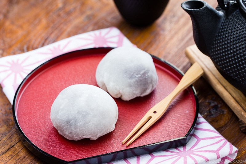 A Japanese red plate containing daifuku mochi.