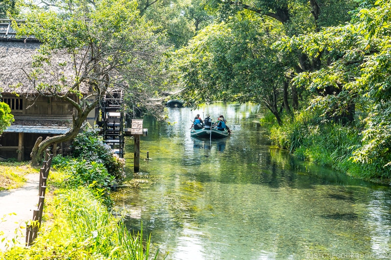 boat cruising on a river next to watermill