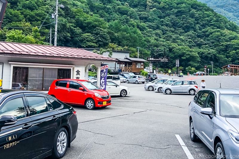 a parking lot with small diner and cars at Sawando