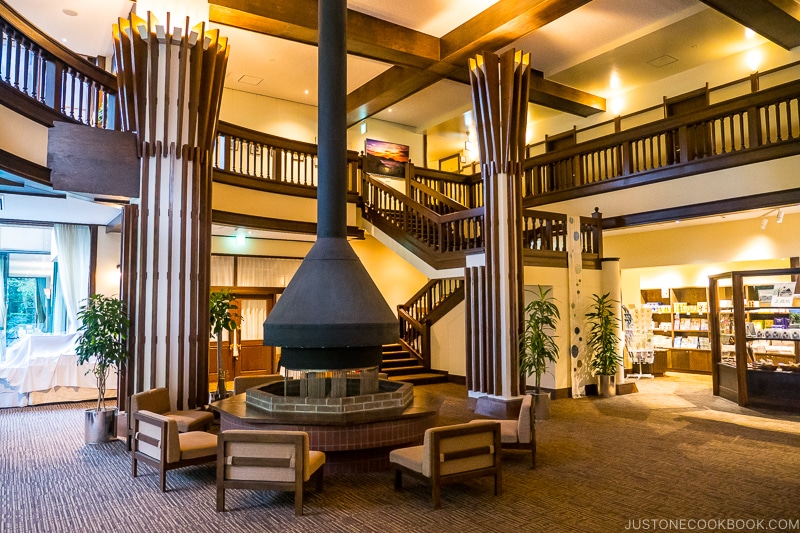 lobby of Kamikochi Alpen Hotel with wood burning firepit and stairs going to the second floor