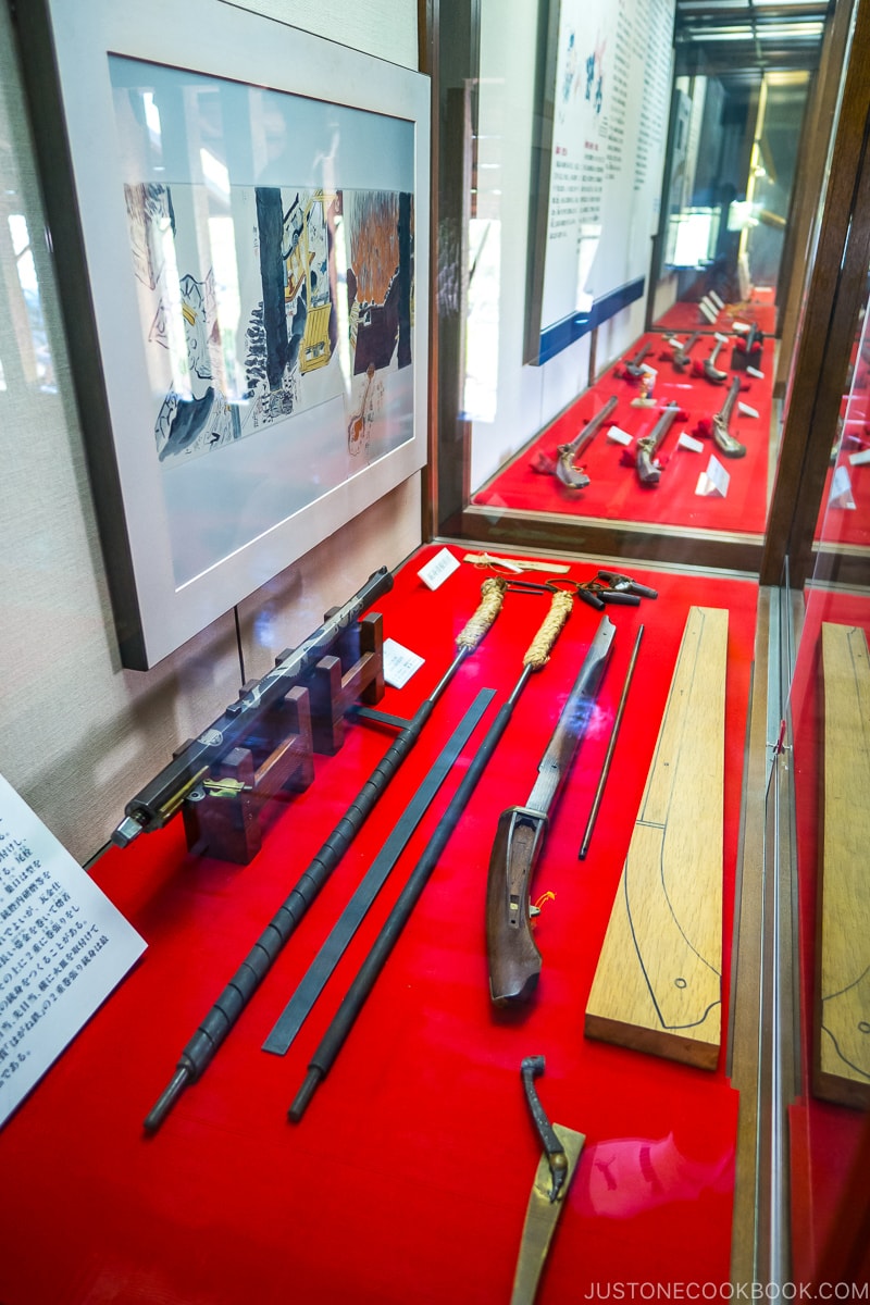 antique guns and accessories in a glass display case