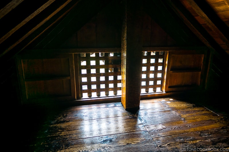 small room with wood floor and a window with cross bars