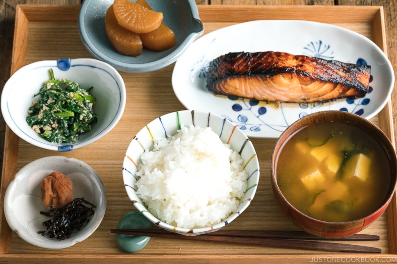 A Japanese meal set with shio koji salmon, miso soup, rice, and side dishes.