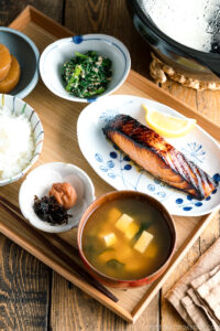 A Japanese meal set with shio koji salmon, miso soup, rice, and side dishes.