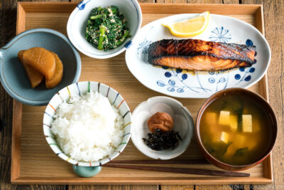 A Japanese meal set with shio koji salmon, miso soup, rice, and side dishes.