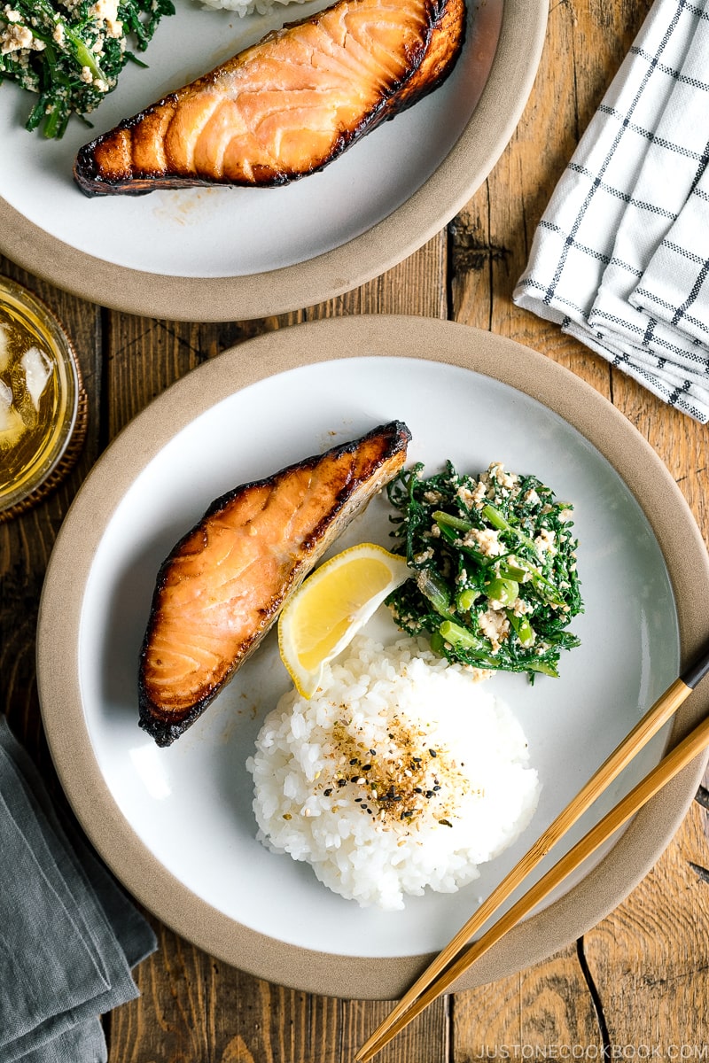 A plate containing Shio Koji Salmon, rice, and vegetable dish.