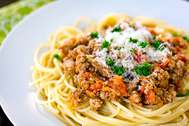 A white plate containing Spaghetti Meat Sauce.