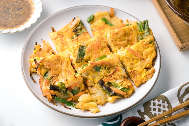 A white plate containing gluten free korean veggie pancake.